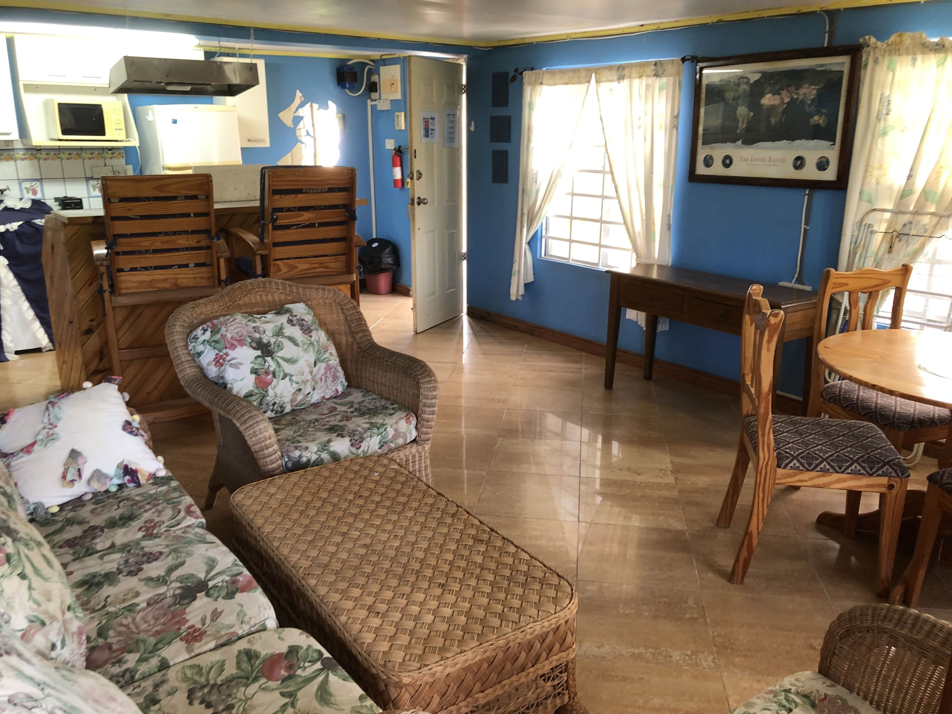 A room with a dining table, chairs, a sofa, and a television.