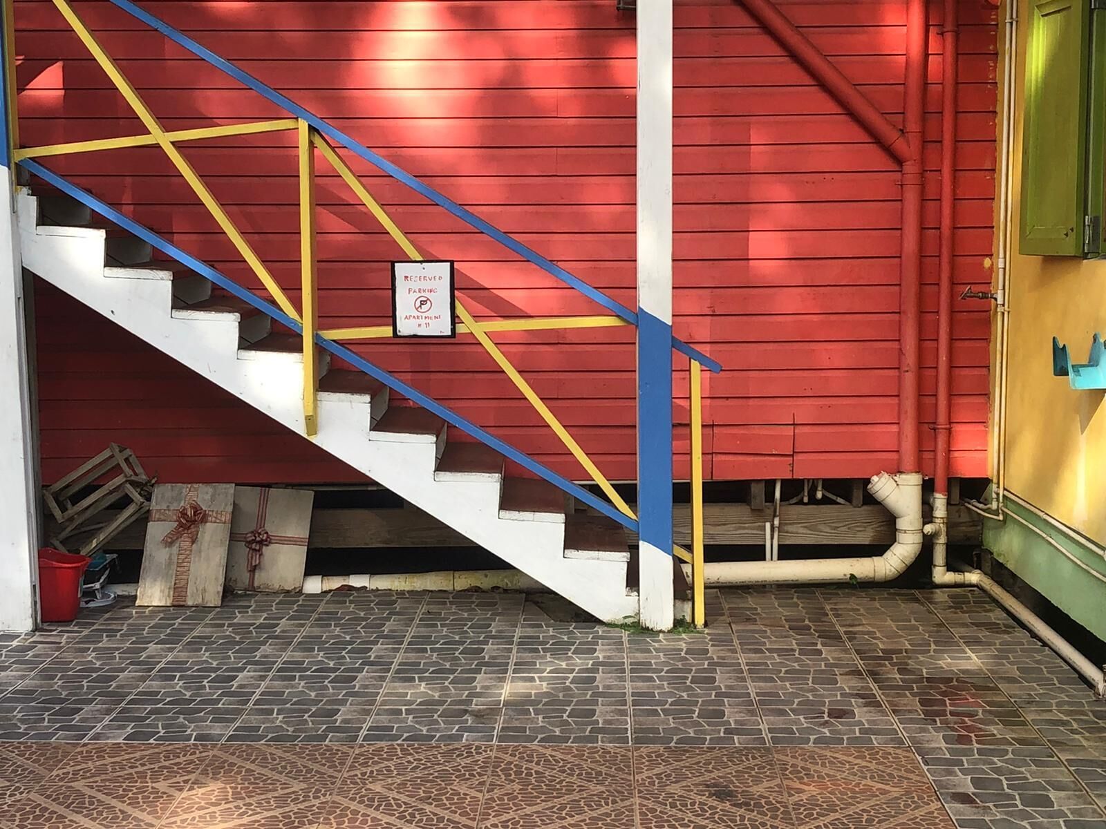Una escalera con barandillas amarillas que lleva a un edificio rojo.