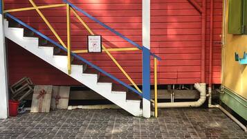 Una escalera con barandillas amarillas que lleva a un edificio rojo.