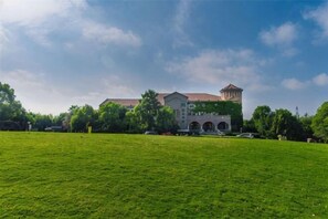 A large building with a central tower, surrounded by a grassy field and trees. - To Journey Wuhu Longshan Campground (Wuhu)