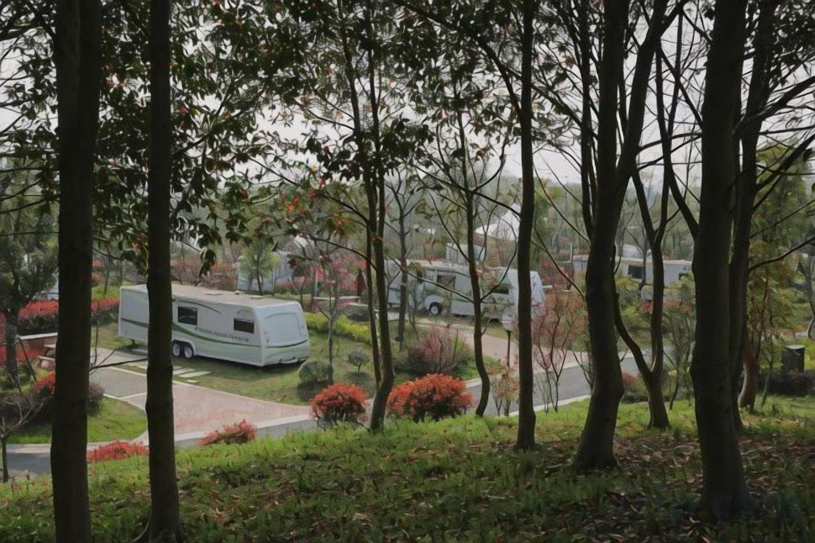 Un barrio residencial con una caravana blanca estacionada en la entrada, rodeado de árboles y arbustos.