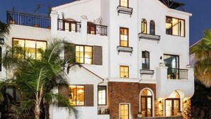 Un edificio de varios pisos con balcones, ventanas grandes y fachada de ladrillo.
