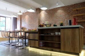Une cuisine avec un mur en briques, des armoires en bois et des luminaires suspendus.