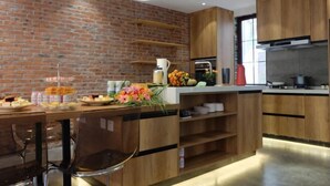 Una cocina moderna con paredes de ladrillo, armarios de madera y una isla central con asientos.