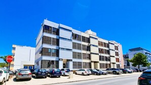 Un immeuble à plusieurs étages doté d’une architecture moderne, caractérisé par une façade plane et de grandes fenêtres.