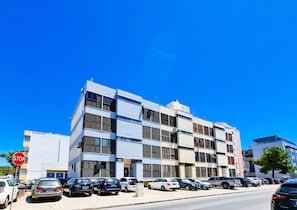 Un edificio de varios pisos con un diseño arquitectónico moderno, que presenta una fachada plana y ventanas amplias.