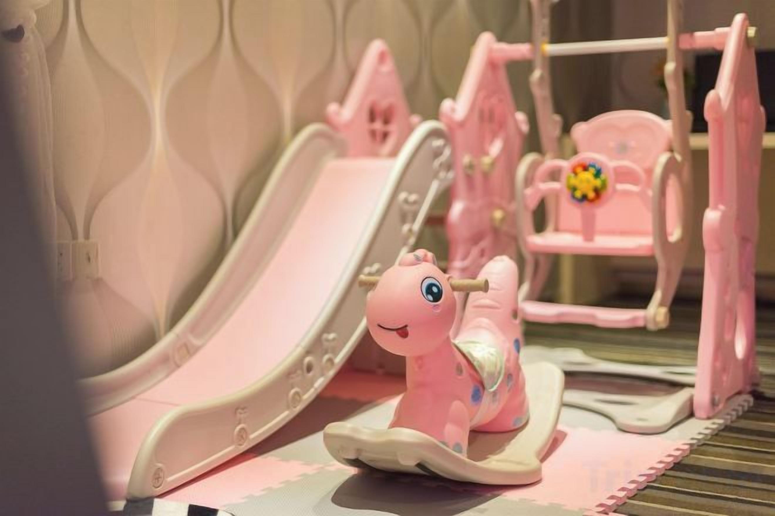 A children's play area with a slide and a small pink chair.