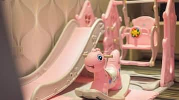 A children's play area with a slide and a small pink chair.