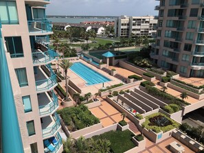 Enjoy serene views from the rooftop pool surrounded by lush greenery and palm trees.