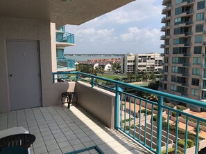 Enjoy the view of the residential area from this balcony with a body of water in sight.