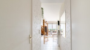 A hallway leading to a dining area with a view of the outdoors. - L'Effet Mer - Studio Apartment, Sleeps 4 (La Richardais)