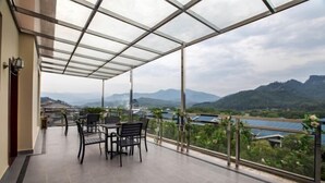 Ein Balkon mit Glasdach und Blick auf eine Berglandschaft.