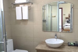 A modern bathroom with a glass shower enclosure, a white sink, and a large mirror. - Xishui Renjia Inn (Wuyishan)