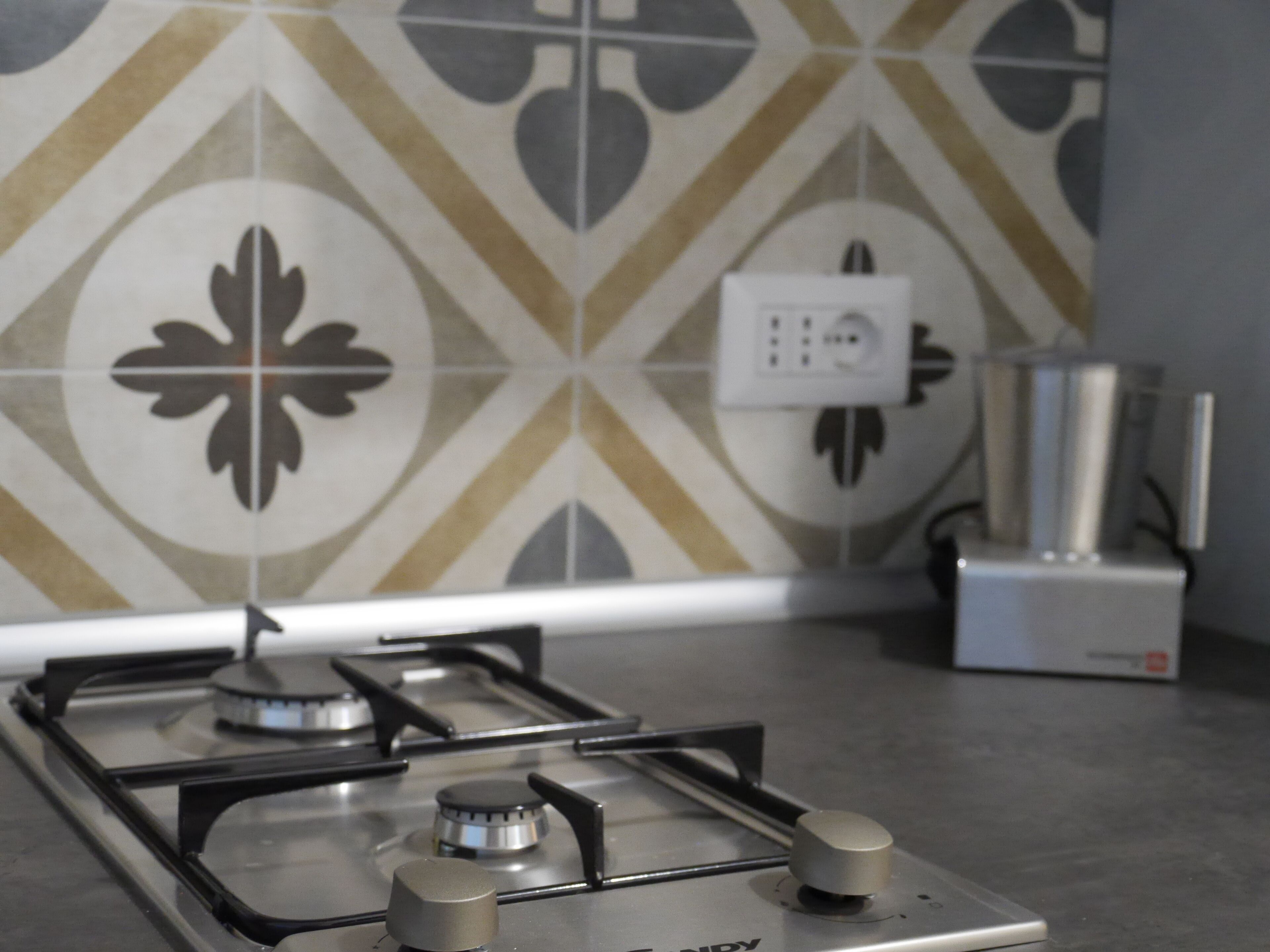 Una cocina con estufa a gas, un enchufe y un dispensador de agua sobre la encimera.