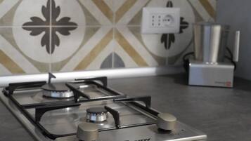 Una cocina con estufa a gas, un enchufe y un dispensador de agua sobre la encimera.