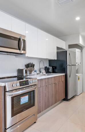 A modern kitchen with stainless steel appliances, wooden cabinets, and a built-in oven.