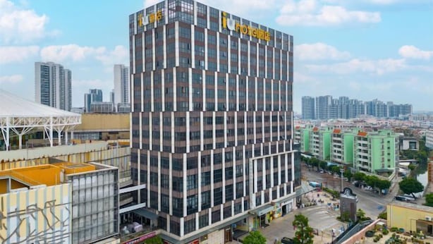 A modern hotel with a glass facade, multiple floors, and a prominent 'Hotel' sign. - IU Hotel (Zhongshan Xiaolan Parkway Plaza) (Zhongshan)