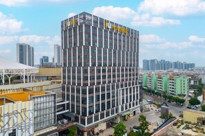 A multi-story hotel with a modern design, featuring a prominent sign at the top. - IU Hotel (Zhongshan Xiaolan Parkway Plaza) (Zhongshan)