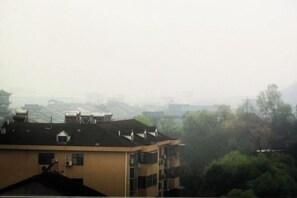A building with multiple floors, a flat roof, and several chimneys. - Mingdelou Hotel (Yichang)