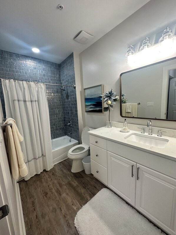 Un bagno moderno con doccia, WC e lavandino.