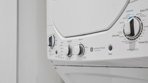 Eine Frontansicht einer weißen Waschmaschine mit Bedienknöpfen, einem Startknopf und einem Hinweis auf die ENERGY GUIDE Konformität.