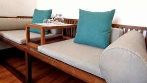 Un banco de madera con asientos acolchados y almohadas color turquesa.