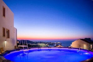 Une piscine offrant une vue sur le paysage urbain au crépuscule.