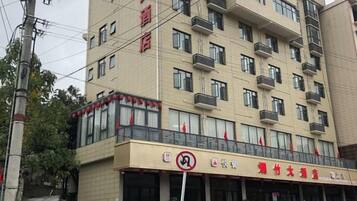Un hôtel à plusieurs étages, doté de balcons et d’un restaurant situé au rez-de-chaussée.