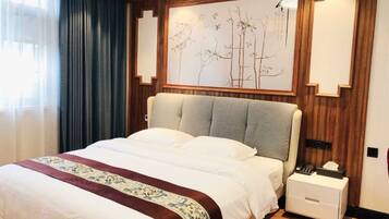 A hotel room with a large bed, a bedside table, and a wall-mounted artwork.