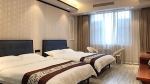 Een hotelkamer met twee bedden, een bureau, een stoel en een raam met gordijnen.