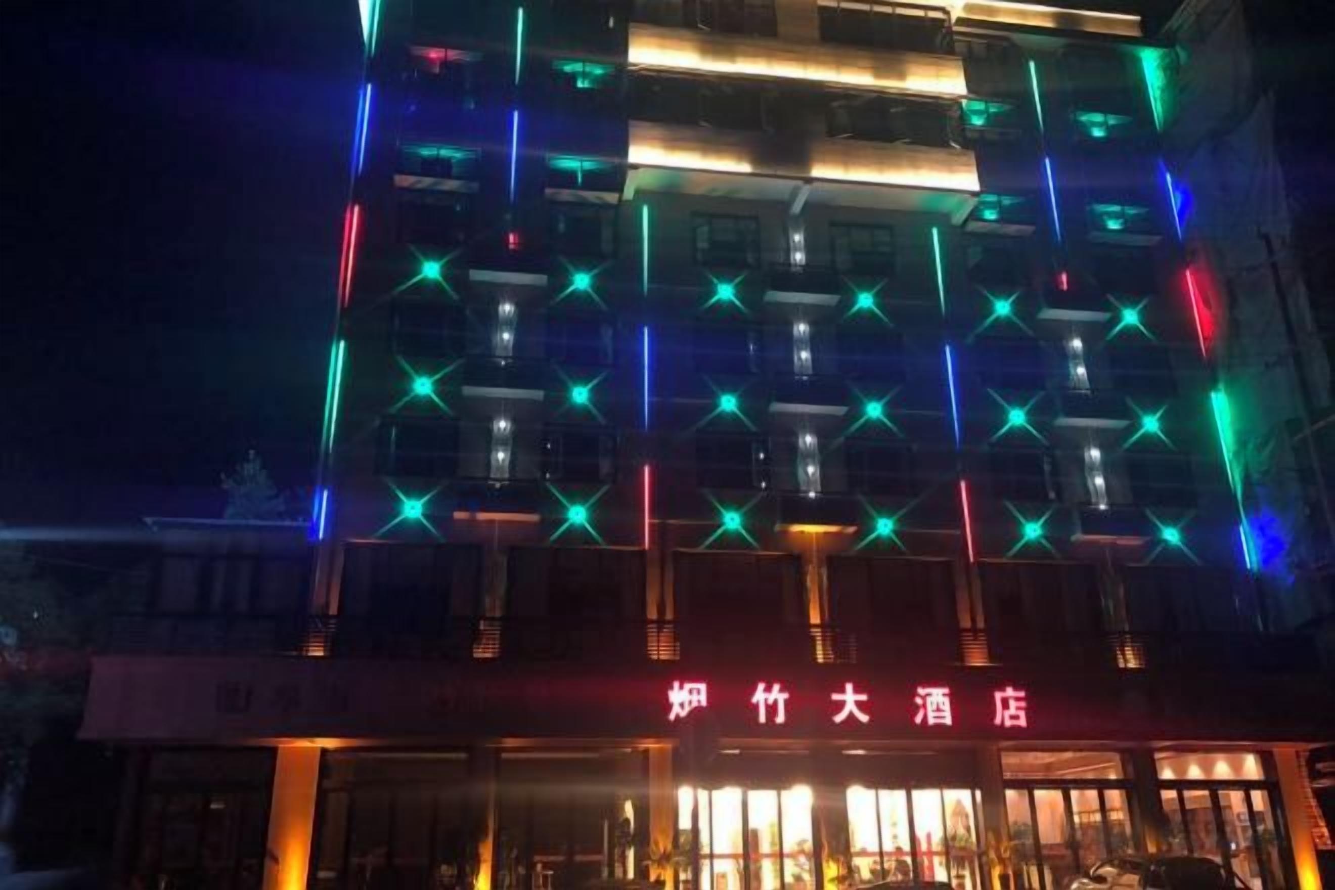 Un edificio con patrones de estrellas iluminados en la fachada y un letrero con caracteres chinos.
