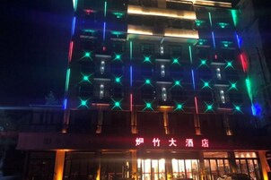 Un edificio con patrones de estrellas iluminados en la fachada y un letrero con caracteres chinos.