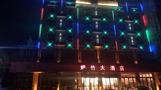 Een hotel met verlichte signage en een moderne gevel.