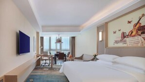 A hotel room with a large bed, a desk, a chair, and a television. - Vienna International Hotel (Qidong Jiangtian Ecological Park) (Qidong)