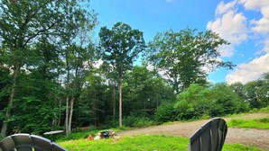 Two Adirondack chairs on a wooden deck overlooking a forested area with a clear sky. - Cabin Retreat in Southern Vermont (Putney)