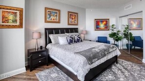 A bedroom with a bed, nightstands, a ceiling fan, and framed artwork on the walls. - 24TH FLOOR WITH STUNNING ENDLESS VIEWS (Holly Hill)