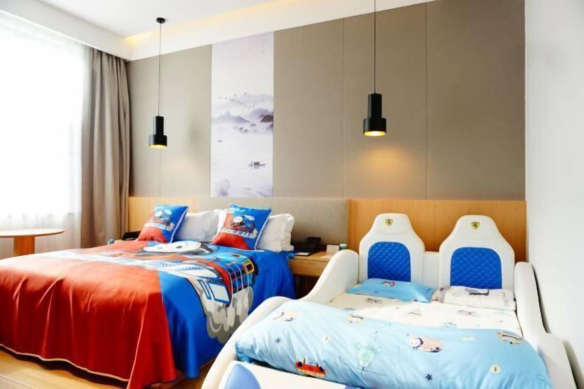 Una habitación de hotel con dos camas, un ventanal con cortinas y una obra de arte colgada en la pared.