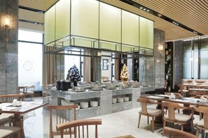 Un restaurante moderno con una isla central, asientos a ambos lados y un ventanal grande.