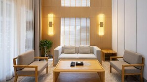 A modern living room with a sofa, two armchairs, a coffee table, and a plant. - Dragon Bay Peninsula Resort Liangzi Lake Wuhan (Wuhan)