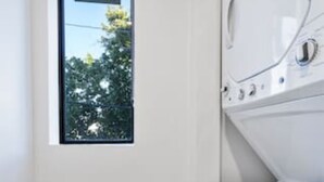 A laundry room with a window, a washing machine, and a dryer. - Miami Suite 308 (Miami)