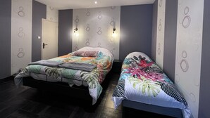 Een moderne slaapkamer met twee eenpersoonsbedden, een deur en wandlampen.