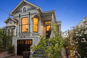 Une maison de style victorien, dotée d’un porche avant imposant, de grandes fenêtres et d’un jardin bien entretenu.
