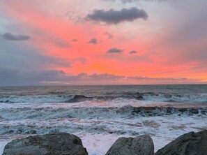 Paesaggio costiero con onde e un cielo al tramonto.