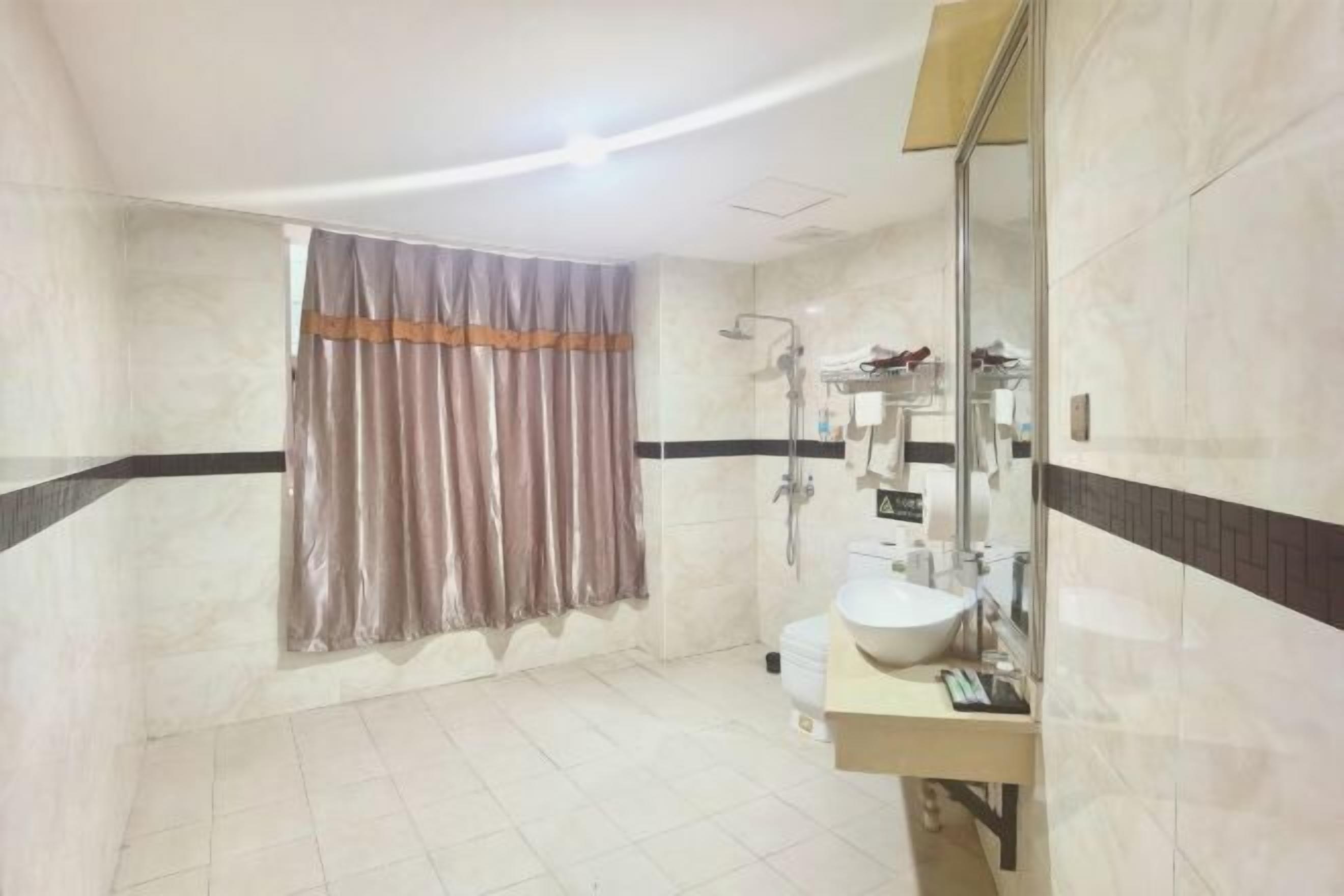 A bathroom with a shower, toilet, and sink.