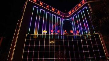 A building with vertical neon lights and a grid-like structure at the bottom.