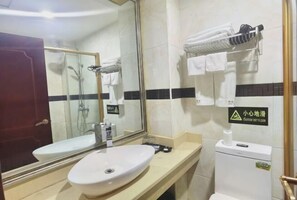 A bathroom with a sink, mirror, shower, and toilet. - Bright Pearl Hotel (Longnan)