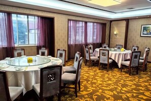 Une salle de conférence avec une table ronde, des chaises et un sol recouvert de moquette.