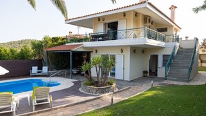 A two-story house with a swimming pool, outdoor seating, and a staircase leading to the upper floor. - Villa Rose (Anavissos)