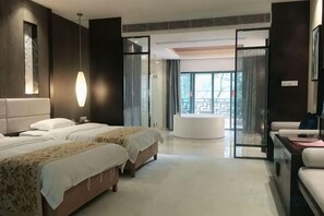 A hotel room with a large bed, a desk, and a view of the outdoors. - Yichun Jing'an · Changlv Qinlu Jiuling Hot Spring Hotel (Kuangzhong Garden) (Jing'an)