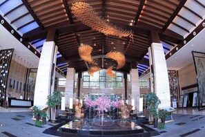 A spacious lobby with a large central fountain, high ceilings, and modern architectural design. - Yichun Jing'an · Changlv Qinlu Jiuling Hot Spring Hotel (Kuangzhong Garden) (Jing'an)
